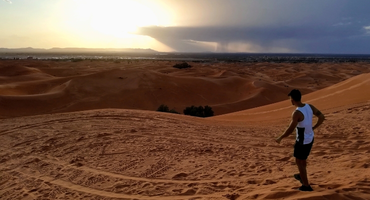 Travellers on a camel trek across Moroccan desert dunes