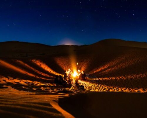 Camel trekking caravan crossing small dunes near M'Hamid, Morocco